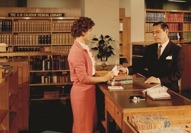 A color still depicting the circulation desk of the A.W. Calhoun Medical Library from the 1963 film, The National Library of Medicine, produced by the United States Public Health Service. National Library of Medicine, Bethesda, Maryland