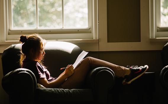 Student studying in a comfy chair in the Matheson Reading Room