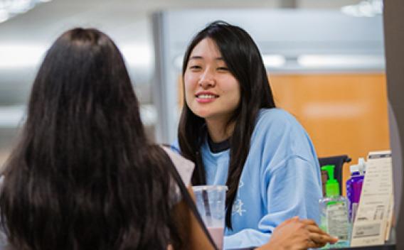 A student assistant talking with a patron at the Woodruff Library service desk