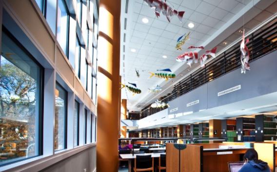 Image of open, airy sunlit view of MacMillan Law Library with mobile paper sculptures hanging from the ceiling