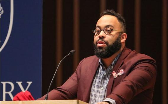 Poet Kevin Young behind a podium