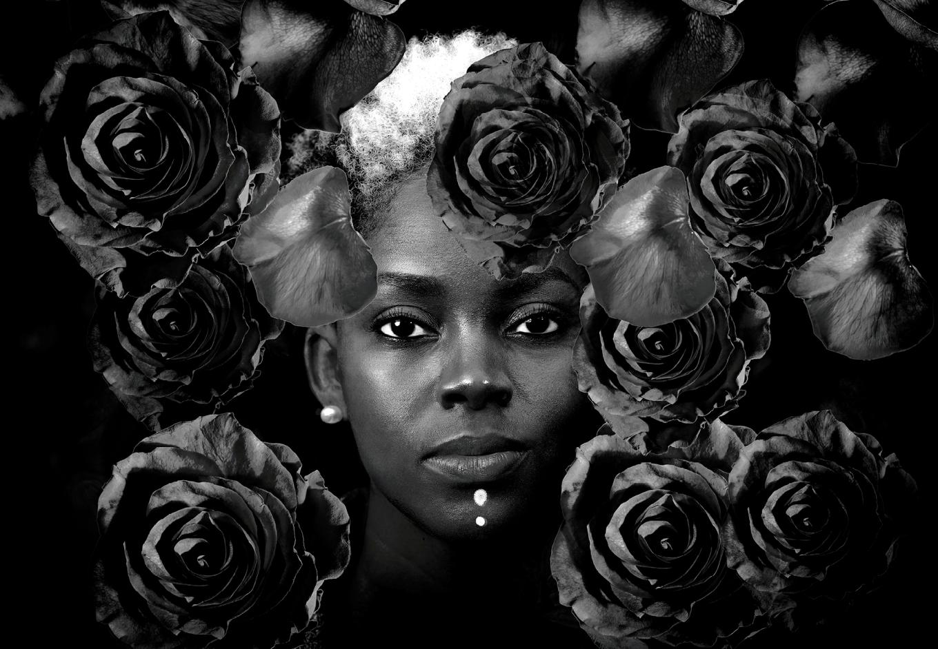 Black and white portrait of woman with floating roses around her. 