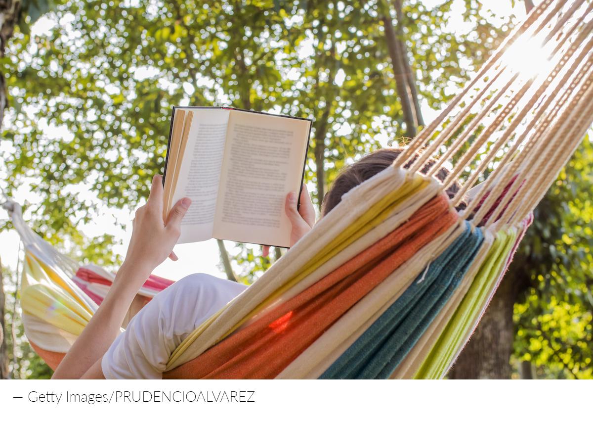 Someone reading in a hammock with shady trees overhead