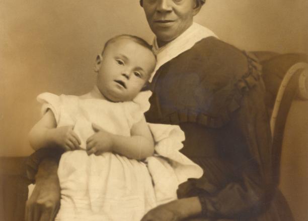 Photo of a black nanny holding a white child.